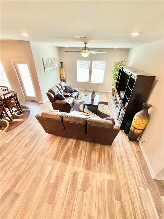 living room featuring light hardwood / wood-style floors and ceiling fan