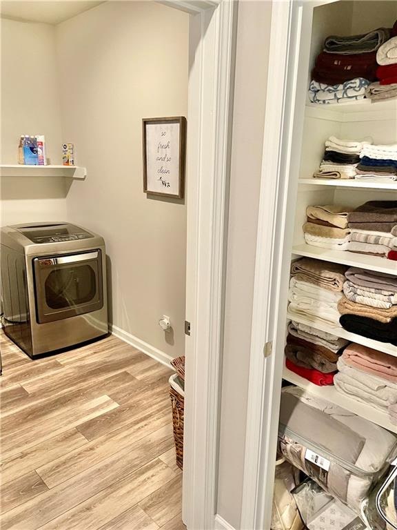 washroom featuring washer / dryer and light hardwood / wood-style floors