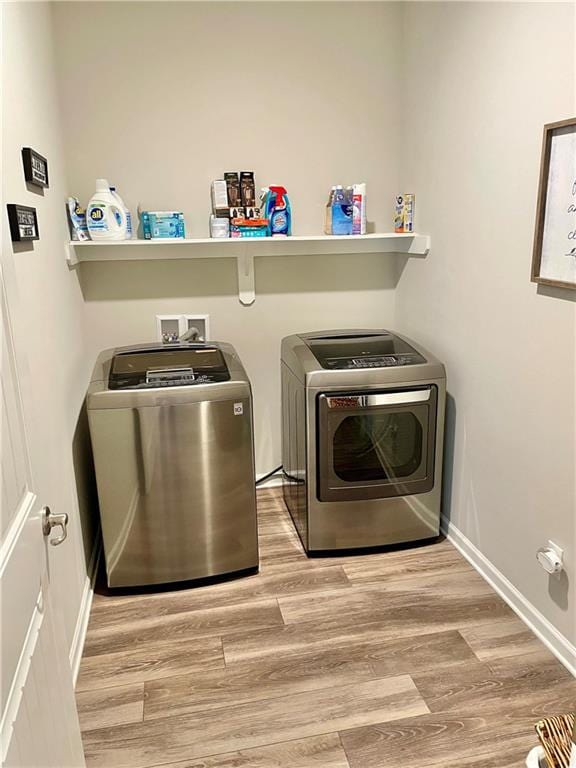 laundry room with hardwood / wood-style floors and separate washer and dryer