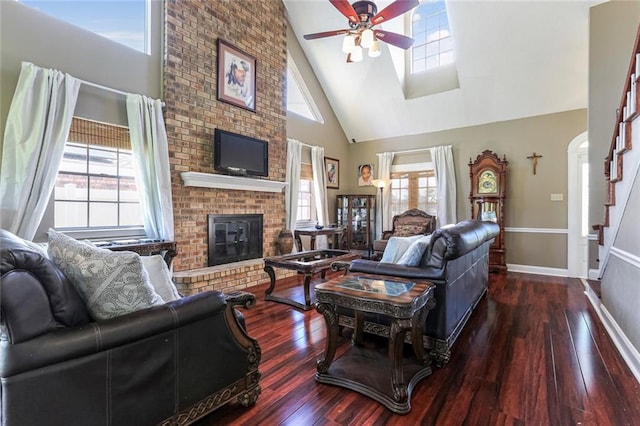 living room with plenty of natural light, ceiling fan, a brick fireplace, and high vaulted ceiling