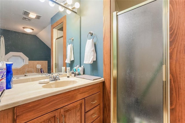 bathroom with vaulted ceiling, a shower with shower door, and vanity