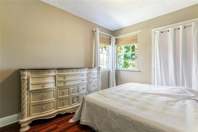 bedroom featuring a textured ceiling and dark wood-type flooring