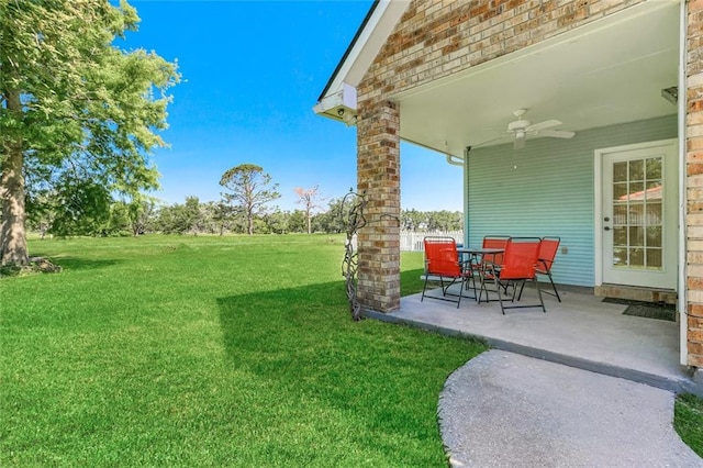 view of yard featuring ceiling fan and a patio