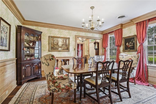 dining space with an inviting chandelier, hardwood / wood-style flooring, and crown molding