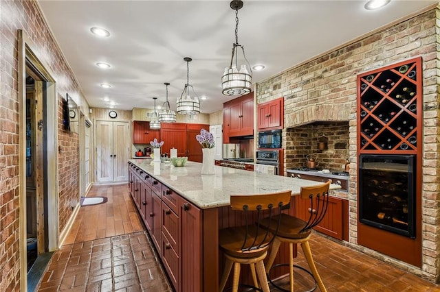 kitchen featuring a large island, beverage cooler, appliances with stainless steel finishes, and brick wall