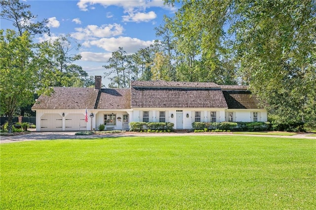 view of front of home with a garage and a front lawn