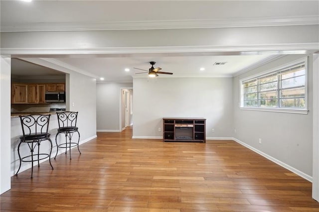 unfurnished living room with light hardwood / wood-style flooring, ceiling fan, and ornamental molding