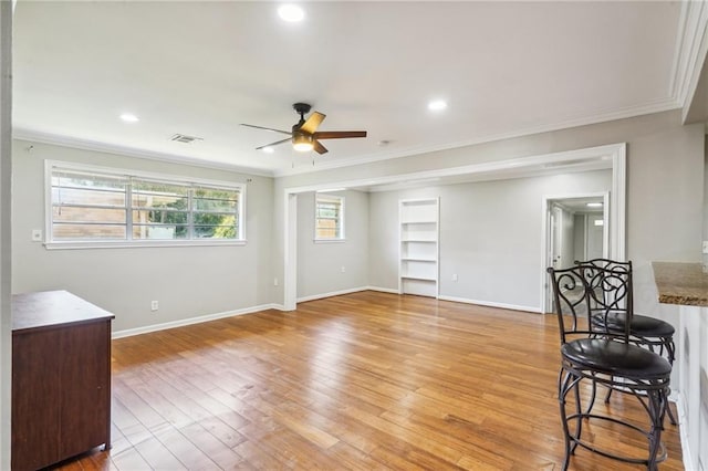 interior space with crown molding, light hardwood / wood-style floors, and ceiling fan