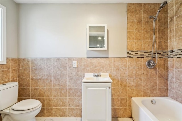 full bathroom featuring tile walls, tiled shower / bath combo, vanity, and toilet