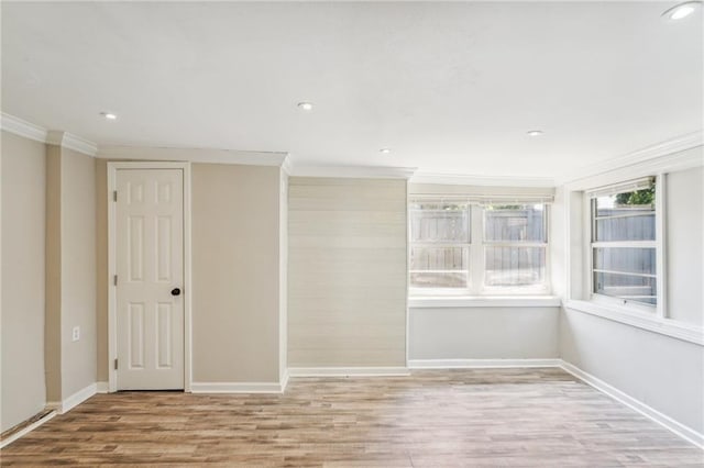 empty room featuring crown molding and light hardwood / wood-style flooring