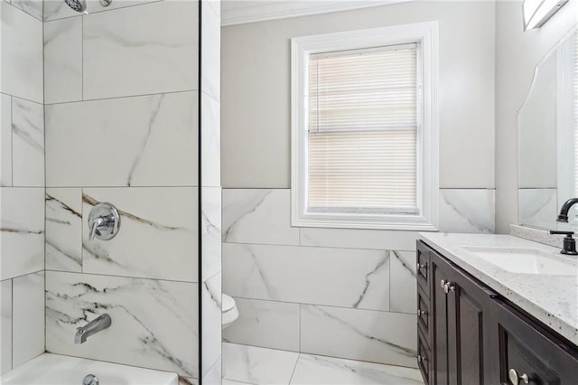 full bathroom featuring vanity, tile walls, tiled shower / bath combo, and toilet