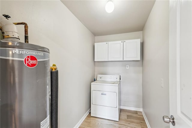 washroom with gas water heater, washer / dryer, light hardwood / wood-style flooring, and cabinets