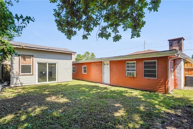 rear view of property featuring a lawn