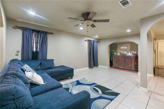 tiled living room featuring ceiling fan and a textured ceiling