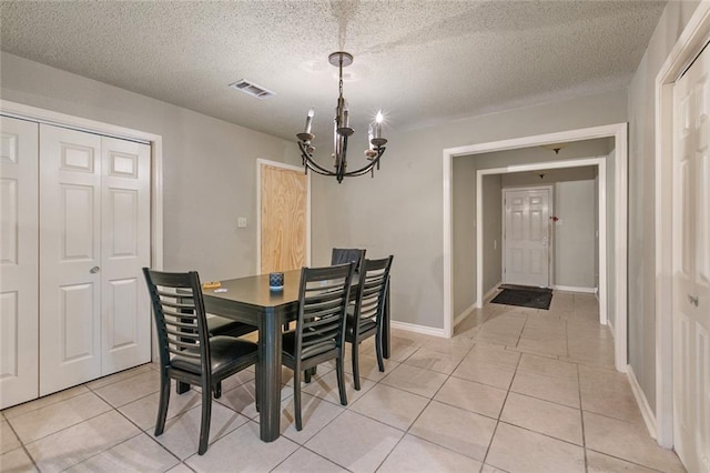 dining room featuring a textured ceiling, light tile patterned flooring, and a chandelier