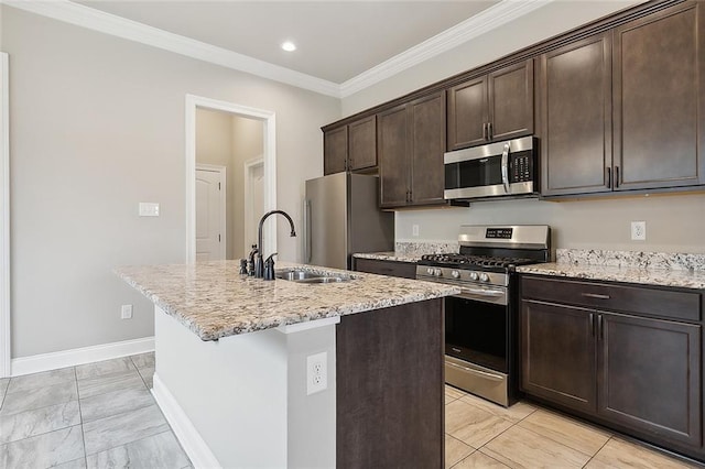 kitchen with appliances with stainless steel finishes, dark brown cabinetry, an island with sink, and light stone counters