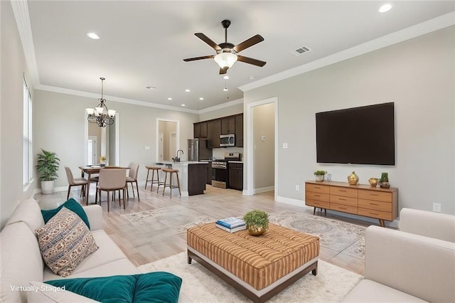 living room featuring ornamental molding, ceiling fan with notable chandelier, and light hardwood / wood-style flooring