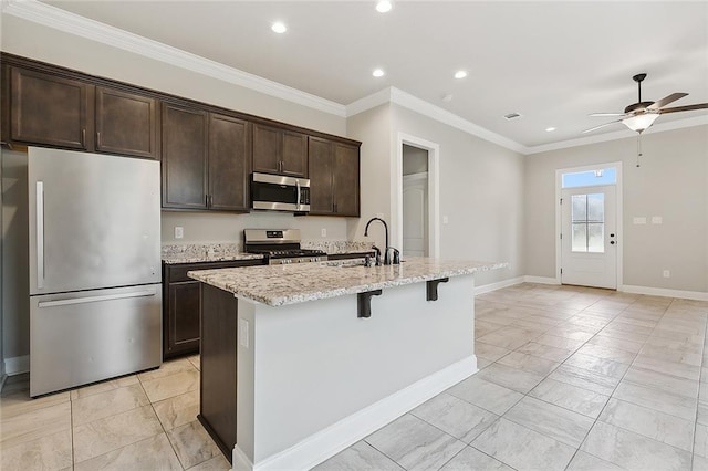 kitchen featuring appliances with stainless steel finishes, ceiling fan, a center island with sink, ornamental molding, and sink