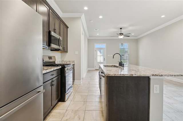 kitchen with ceiling fan, sink, a center island with sink, stainless steel appliances, and crown molding