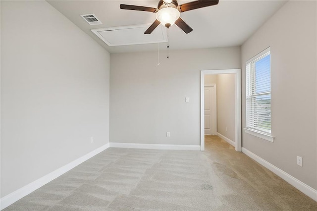 carpeted spare room featuring ceiling fan and plenty of natural light