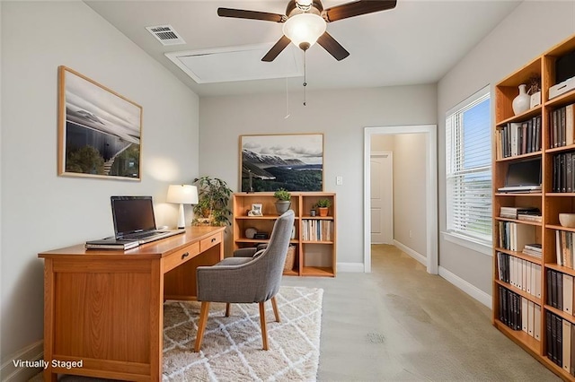 carpeted office space with ceiling fan