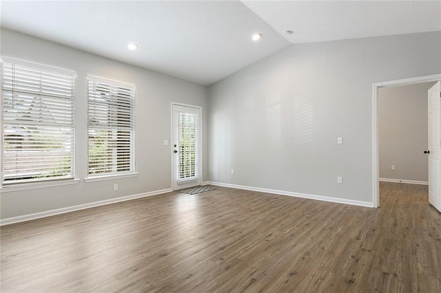 spare room featuring dark hardwood / wood-style floors and vaulted ceiling