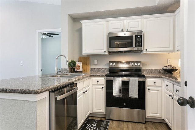 kitchen with white cabinets, sink, ceiling fan, appliances with stainless steel finishes, and kitchen peninsula