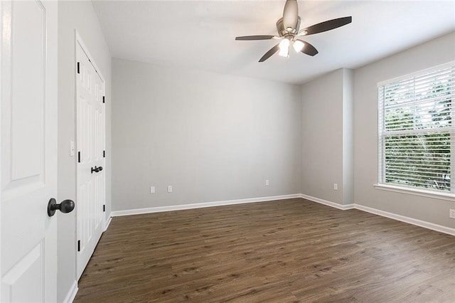 spare room with ceiling fan, a healthy amount of sunlight, and dark hardwood / wood-style flooring