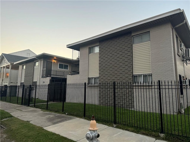 property exterior at dusk with a lawn