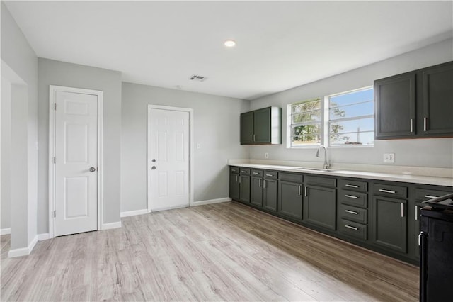 kitchen with light hardwood / wood-style flooring, black range with electric stovetop, and sink