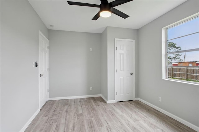 unfurnished bedroom featuring multiple windows, ceiling fan, and light hardwood / wood-style floors