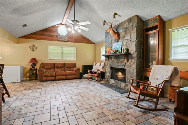 living room with a stone fireplace, a textured ceiling, lofted ceiling, and ceiling fan