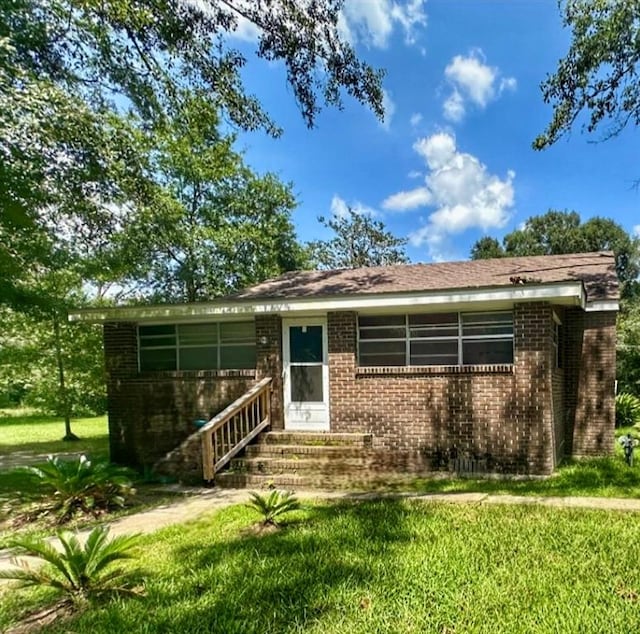 rear view of property featuring a yard