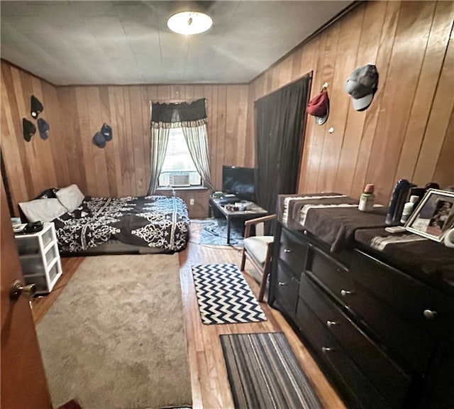 bedroom featuring wooden walls and hardwood / wood-style flooring