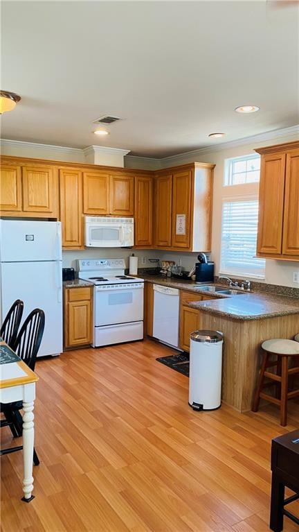 kitchen with ornamental molding, light hardwood / wood-style floors, and white appliances