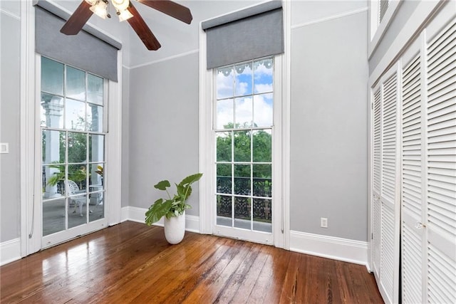 doorway to outside with ceiling fan, hardwood / wood-style flooring, and crown molding