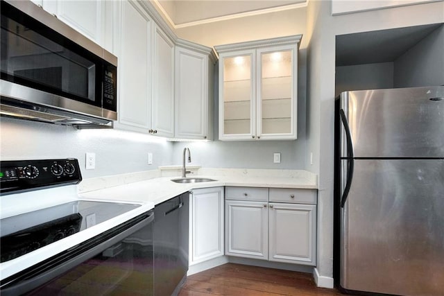 kitchen featuring stainless steel appliances, dark hardwood / wood-style floors, sink, and white cabinetry