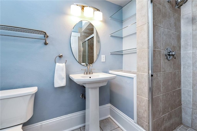 bathroom featuring toilet, a shower with door, and tile patterned floors