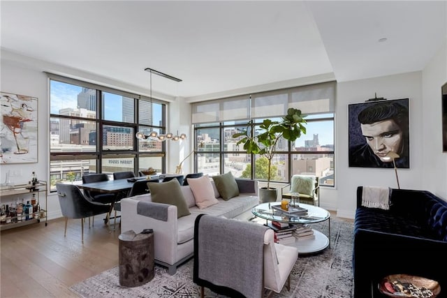 living room with an inviting chandelier, baseboards, and hardwood / wood-style floors