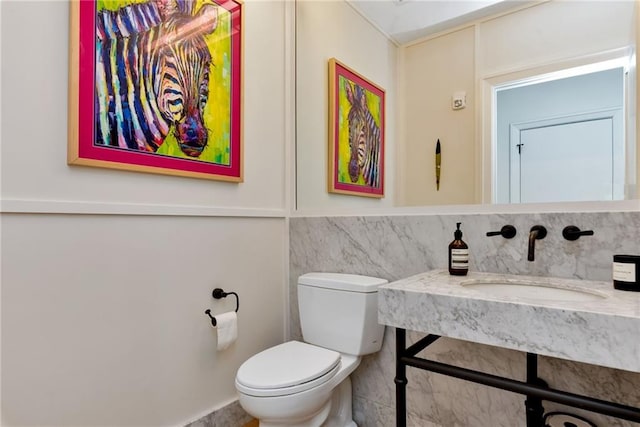 half bathroom featuring toilet and a sink
