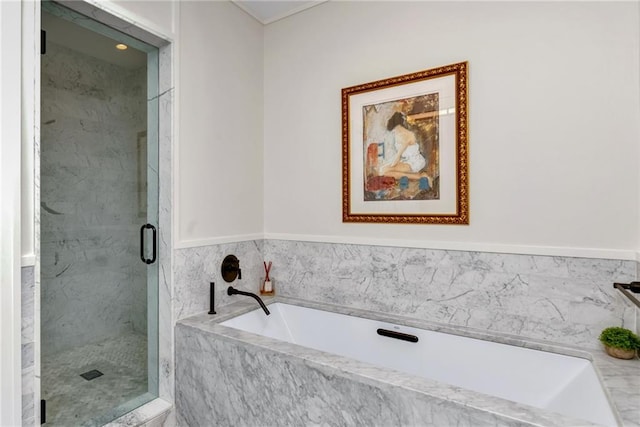bathroom featuring a marble finish shower and a bath