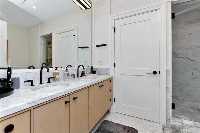 bathroom featuring a shower with door and vanity