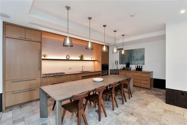 kitchen with oven, backsplash, sink, decorative light fixtures, and stainless steel gas stovetop