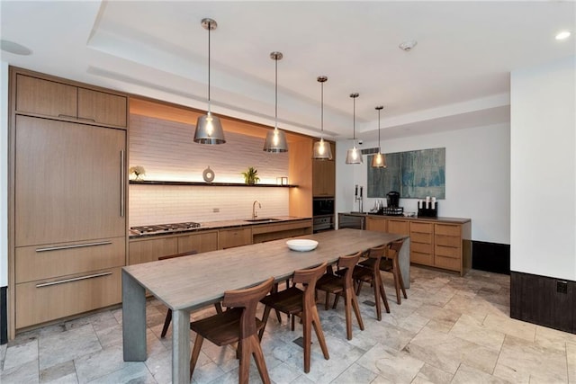 dining space featuring a raised ceiling, recessed lighting, and stone finish floor