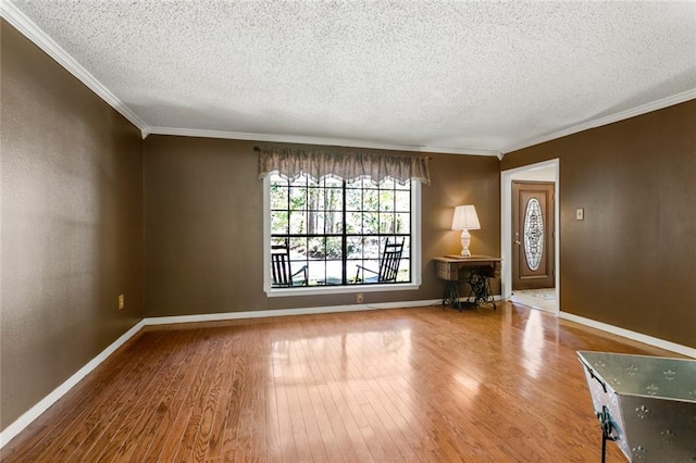 unfurnished room featuring wood-type flooring, a textured ceiling, and crown molding