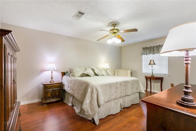 bedroom featuring ceiling fan, dark wood-type flooring, and a textured ceiling