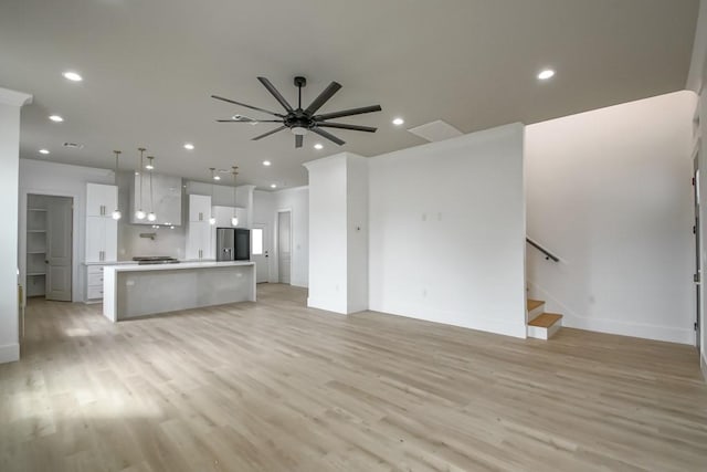 unfurnished living room with ceiling fan and light hardwood / wood-style floors