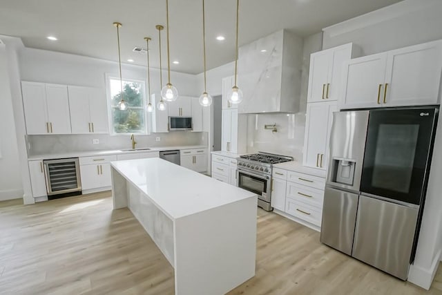 kitchen with wine cooler, stainless steel appliances, sink, and white cabinetry