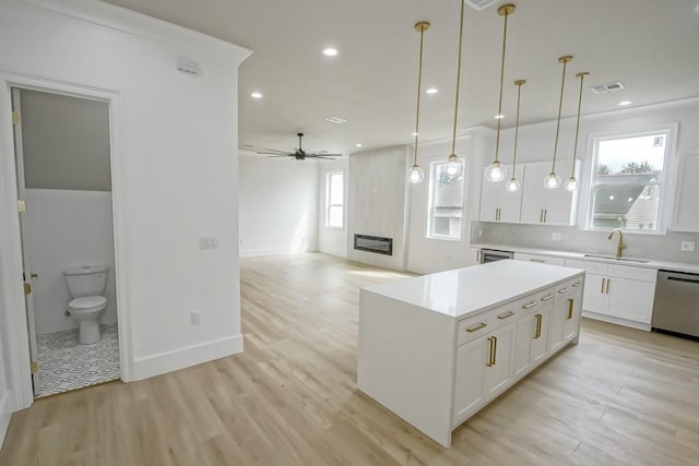 kitchen featuring hanging light fixtures, stainless steel dishwasher, ceiling fan, and plenty of natural light