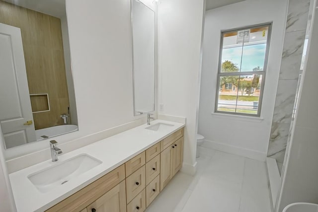 bathroom featuring tile patterned flooring, a washtub, vanity, and toilet